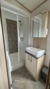 y baño con lavabo y ducha. en 3 Bedroom Caravan in Tattershall lakes Holiday Park, en Tattershall