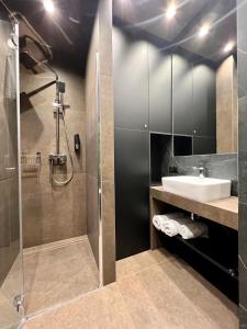uma casa de banho com um lavatório e um chuveiro em Apartament SPOT Klonowa em Kielce