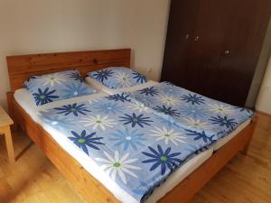 a bed with a blue and white comforter and pillows at Apartmaji Tim in Izola