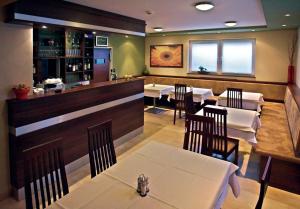 restauracja ze stołami i krzesłami oraz bar w obiekcie Promedicum Panzio w mieście Veszprém