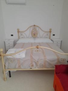 um quarto com uma cama branca com uma estrutura em madeira em Domus Veretum em Morciano di Leuca