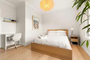 a bedroom with a bed with a desk and a chair at Sunlit 2BR Coastal Charm Bondi Beach Beach View in Sydney