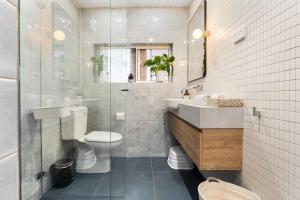 a bathroom with a toilet and a sink and a mirror at Sunlit 2BR Coastal Charm Bondi Beach Beach View in Sydney