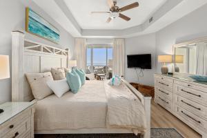 a bedroom with a bed with a ceiling fan at Crescent at Miramar 406 - Sheer Bliss in Destin