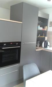 a kitchen with a oven and a blue chair at Kleines Landhaus in Stromberg