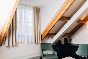 een woonkamer met een stoel en een raam bij Factory Hotel in Beveren