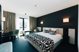 um quarto de hotel com uma cama com uma parede preta em Factory Hotel em Beveren