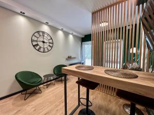 a room with a table and chairs and a clock on the wall at Apartament SPOT Klonowa in Kielce