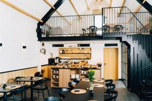 un restaurante con mesas y sillas y una escalera en Factory Hotel en Beveren