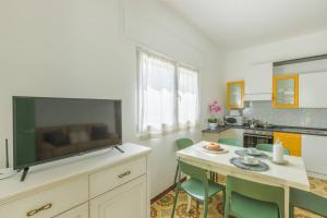 a kitchen with a large tv and a table with chairs at Casa Tina con piscina in San Vito dei Normanni