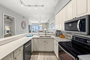 a large kitchen with a sink and a microwave at Crescent at Miramar 406 - Sheer Bliss in Destin