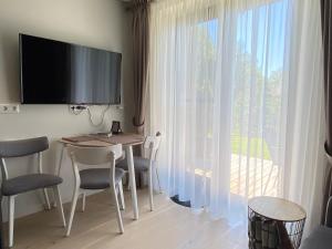 a room with a table and chairs and a large window at Pervalka Apartaments With Large Terrace in Pervalka