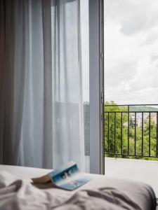 ein Buch auf einem Bett vor einem Fenster in der Unterkunft City Inn Lviv Smart Hotel in Lwiw