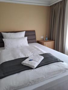 ein Bett mit einer schwarz-weißen Decke drauf in der Unterkunft Hotel Rhin Inn in Fehrbellin
