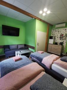 2 camas en una habitación con paredes verdes y sofá en Stern Zimmer vermiten, en Hückelhoven