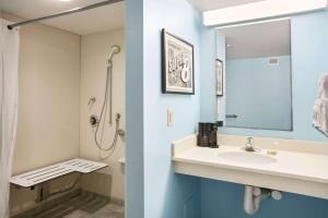 La salle de bains est pourvue d'un lavabo et d'une douche. dans l'établissement Super 8 by Wyndham Mount Laurel, à Mount Laurel