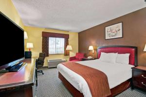 a hotel room with a bed and a flat screen tv at Baymont by Wyndham Washington Court House in Jeffersonville