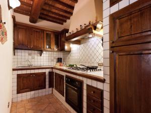 cocina con armarios de madera y horno con fogones en Modern Holiday Home in Foiano della Chiana with Pool en Foiano della Chiana