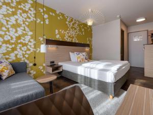 a bedroom with a bed and a couch at Mercure Hotel Stuttgart Gerlingen in Gerlingen