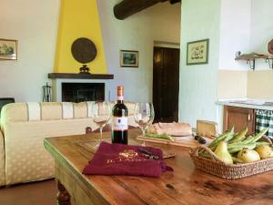 uma mesa com uma garrafa de vinho e dois copos em Serene farmhouse in Dicomano with swimming pool em Dicomano
