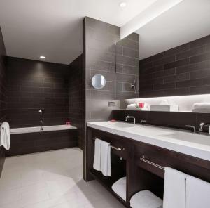 a bathroom with a large sink and a bath tub at Hyatt Centric Times Square New York in New York