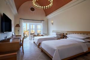a hotel room with two beds and a chandelier at Sheraton Miramar Resort El Gouna in Hurghada