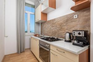 una cucina con fornello forno superiore accanto a una finestra di Step to the Sea apartment a Fiume (Rijeka) Altre 17 foto