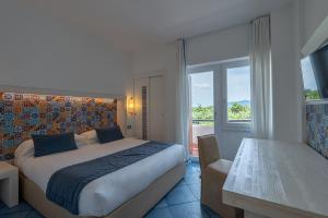 a bedroom with a bed and a table and a window at Hotel Oasi Di Kufra in Sabaudia