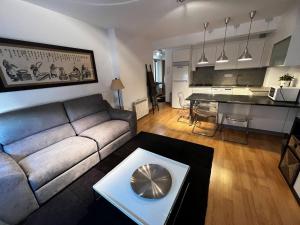 een woonkamer met een bank en een keuken bij Oktheway Santander 2 in A Coruña