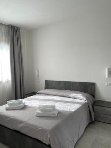 a bedroom with a large bed with two towels on it at Olbios Apartment in Olbia