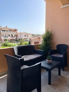 a patio with two chairs and a table on a balcony at Olbios Apartment in Olbia