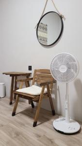 a mirror and a chair and a table with a fan at 山林間 - 露營 旅居 Camping & BNB in forests in Tai'an