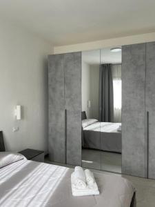 a bedroom with two beds and a large mirror at Olbios Apartment in Olbia