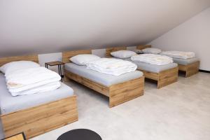 3 camas con almohadas blancas en una habitación en POKOJE JURAJSKI ZAKAMAREK, 