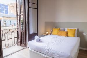 a bedroom with a white bed and a large window at Aticco Living Gràcia - Apartments Rooftop in Barcelona