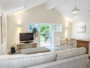 a living room with a couch and a television at Millside, Bosham in Bosham