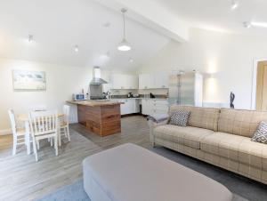 a living room and kitchen with a couch and a table at Millside, Bosham in Bosham