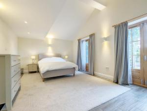 a bedroom with a bed and a large window at Millside, Bosham in Bosham
