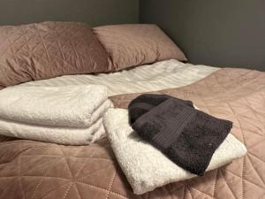 a bed with a pile of towels on it at Aska Apartment in Reykjavík