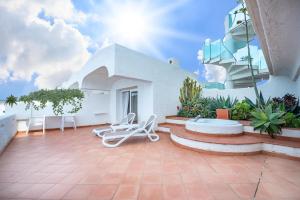 a patio with two lounge chairs and a building at Hotel Oasi Di Kufra in Sabaudia