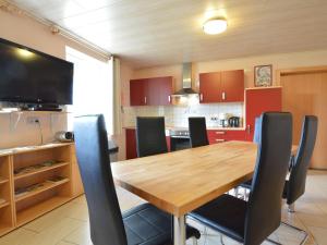 una cucina con tavolo in legno e sedie nere di Comfy Holiday Home in Burg Reuland with Sauna Terrace BBQ a Burg-Reuland