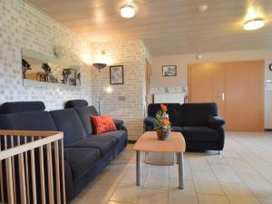 ein Wohnzimmer mit einem blauen Sofa und einem Tisch in der Unterkunft Comfy Holiday Home in Burg Reuland with Sauna Terrace BBQ in Burg-Reuland