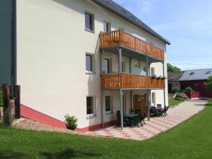 uma grande casa branca com um deque ao lado em Comfy Holiday Home in Burg Reuland with Sauna Terrace BBQ em Burg-Reuland