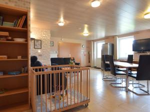 ein Esszimmer mit einem Kinderbett, einem Tisch und Stühlen in der Unterkunft Comfy Holiday Home in Burg Reuland with Sauna Terrace BBQ in Burg-Reuland