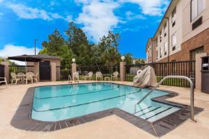 a swimming pool in the courtyard of a building at Comfort Suites North Mobile in Saraland