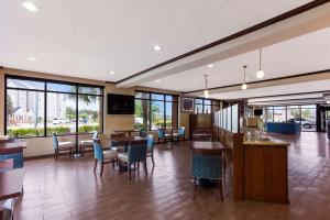 Comfort Suites North Mobile في سارالاند: لوبي كبير به طاولات وكراسي ونوافذ