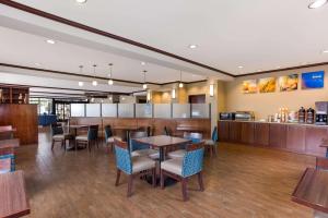 Comfort Suites North Mobile في سارالاند: مطعم بطاولات وكراسي وبار