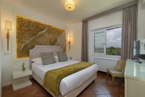 a hotel room with a bed and a window at Hotel Oasi Di Kufra in Sabaudia