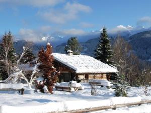 una cabina nella neve con montagne sullo sfondo di Typical Cottage in Bellamonte Italy with bubble bath a Bellamonte
