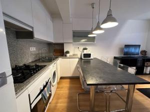 eine große Küche mit Tisch und Herd in der Unterkunft Oktheway Santander Street 5 in A Coruña + 25 Fotos